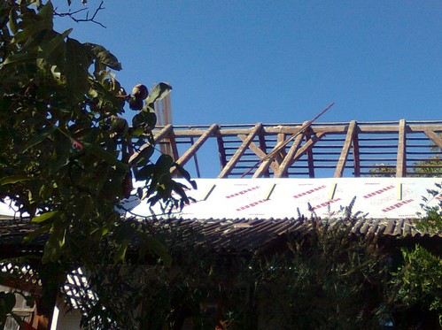 A modern vapor barrier being installed over the rafters.