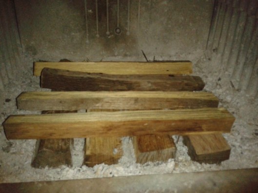 Second layer of stove wood perpendicular to first layer.