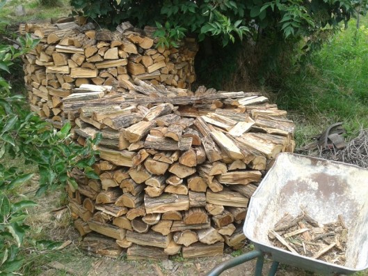 This shows a closeup of how I interlock the wood within the pile. In the foreground is a log turned at a 90 degree angle to the others in the front, and you can see the wood log just to the upper left and right of this log in the front that are then placed across the boundary of the inner and outer circle of logs. This inner log helps lock the inner and outer circle together within the pile.