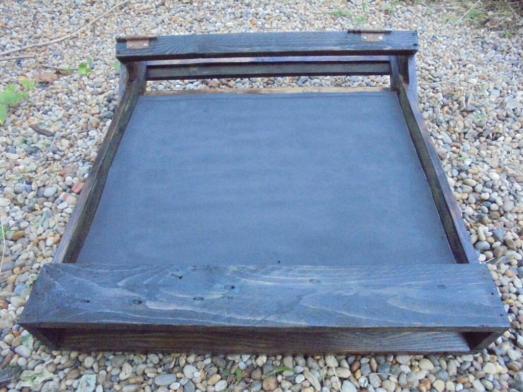 Solar dryer preheater frame with heat absorbing metal plate.